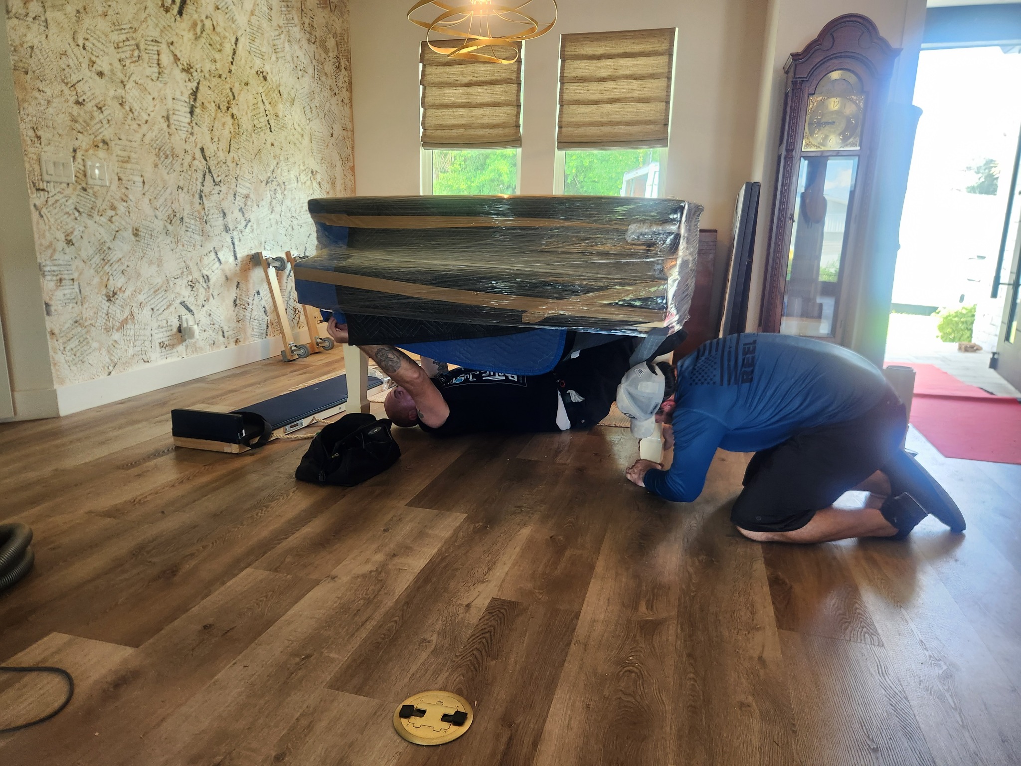 Triton Moving crew carefully moving a grand piano inside a Florida home
