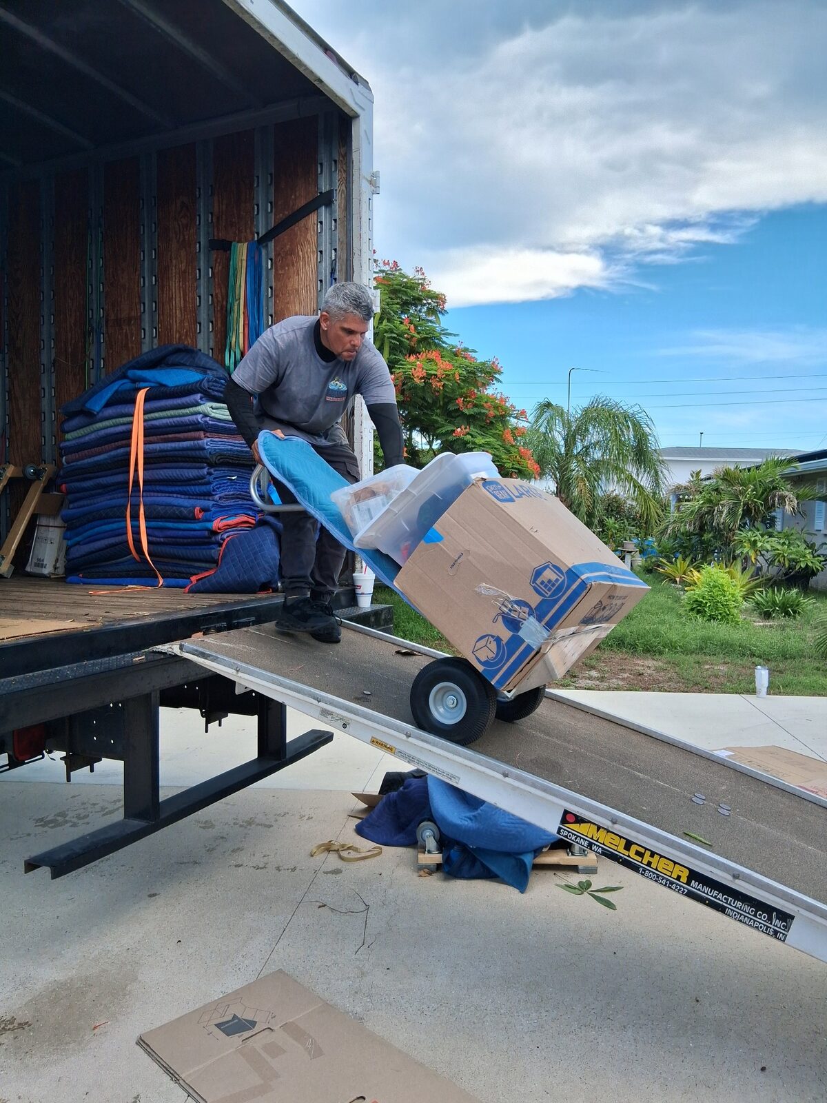 Triton Moving professional loading boxes safely down a truck ramp